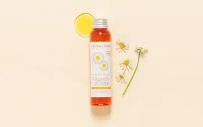 Flacon d'huile de pâquerette Aroma-Zone, avec des pâquerettes. Attention, l'huile de pâquerette danger potentiel pour certaines peaux.