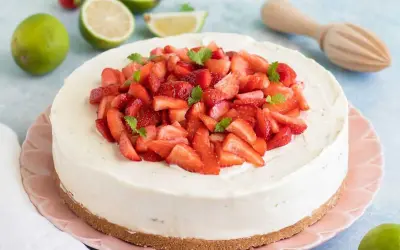 En krämig vit choklad cheesecake toppad med färska jordgubbar och mynta. En perfekt sommardessert!