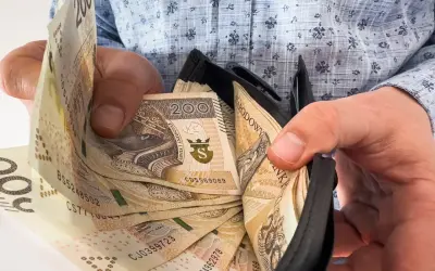 Ręce trzymają portfel z banknotami 200 zł. To nagroda jubileuszowa za 15 lat pracy, symbol docenienia za lata zaangażowania.