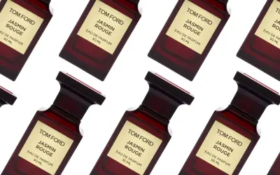 Wiele flakonów perfum Tom Ford Jasmin Rouge, każdy z charakterystyczną złotą etykietą i ciemnoczerwonym szkłem.