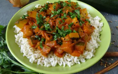 Pyszna cukinia w curry z ryżem, posypana świeżą natką pietruszki i czarnuszką. Aromatyczne danie, które zachwyci każdego.
