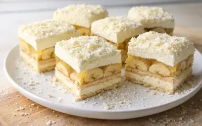 Pyszna krajanka z bananami, galaretką i bitą śmietaną, posypana wiórkami białej czekolady.