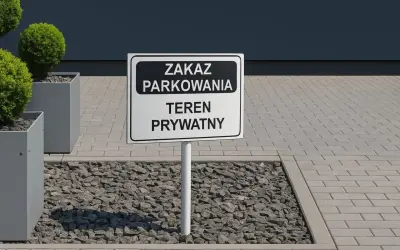 Znak "Zakaz parkowania - teren prywatny" na tle nowoczesnego budynku i zieleni.