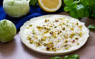Delikatne carpaccio z kalarepy, posypane pistacjami i parmezanem, z dodatkiem świeżej bazylii i cytryny.