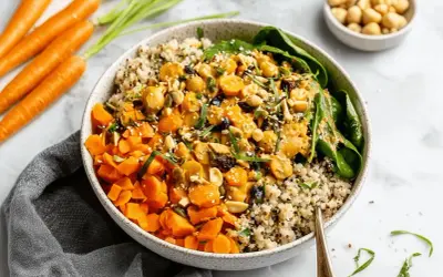 Bunter Quinoa-Bowl mit Karottenwürfeln, Kichererbsen und Nüssen. Ein leckeres Beispiel für Karotten Rezepte.