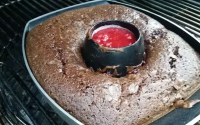 Gâteau au barbecue, un délice chocolaté avec un cœur de coulis de fruits rouges, prêt à être dégusté.