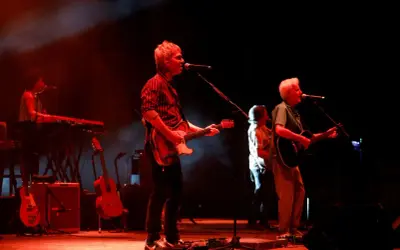 Kiko Veneno y Martirio en concierto, con luces rojas y humo. Kiko toca la guitarra eléctrica, Martirio la acústica.