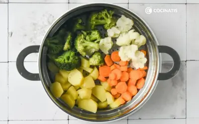 Un vaporizador lleno de un colorido panache de verduras: brócoli, coliflor, zanahorias y patatas cortadas.