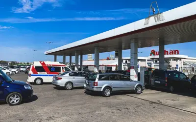 Stacja paliw Auchan. Samochody, w tym ambulans, tankują przy dystrybutorach. Sprawdzanie auchan ceny paliw.