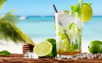 Orzeźwiający mohito alkohol z limonką i miętą na tle plaży. Idealny na wakacje!
