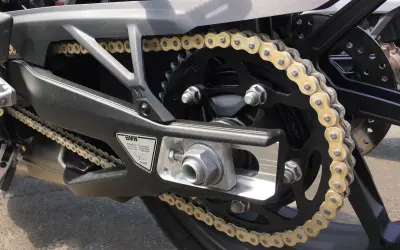Złoty łańcuch motocyklowy BMW na tylnym kole. Dowiedz się, jak rozkuć łańcuch motocyklowy, by go wymienić lub skrócić.