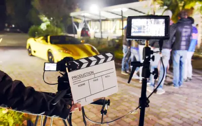 Na planie filmowym, gdzie kręcono scenę z żółtym sportowym autem, klaps filmowy zapowiada, ile zarabiają statyści na planach filmów Patryka Vegi i innych hitów.