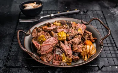 Joue de bœuf effilochée, tendre et savoureuse, servie avec des légumes fondants. Un délice pour les amateurs de viande.