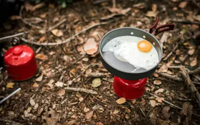 Stekt ägg i stekpanna på campingkök. Enkel och bra vandringsmat som ger energi för äventyret.