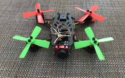 Ein kleiner, bunter Quadrocopter mit roten und grünen Propellern, bereit für aufregendes FPV fliegen.