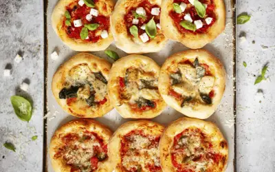 Gotowe ciasto na pizzę w różnych wariantach: z fetą i bazylią, z karczochami i szpinakiem, oraz z warzywami.