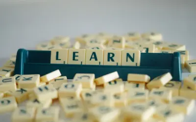 Litery na kafelkach układają się w słowo LEARN, symbolizując naukę i rozwijanie słownictwa. To świetny przykład na word formation C1.