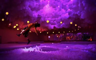 A person in a yellow shirt leaps into a ball pit at the balloon museum London, surrounded by purple clouds and yellow lights.