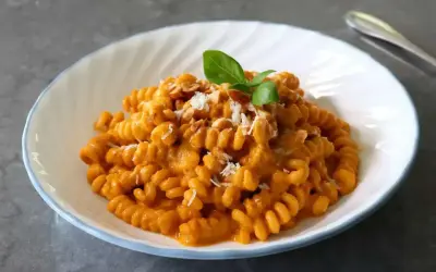 Pyszny makaron fusilli w kremowym sosie pomidorowym, posypany parmezanem i orzeszkami. Idealny makaron na obiad.