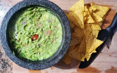 Färdiggjord guacamole i en mortel, redo att serveras med tortillachips. Ett enkelt guacamole recept för alla.