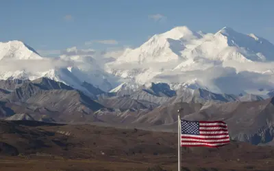 US-Flagge vor schneebedeckten Bergen des Denali Nationalparks.