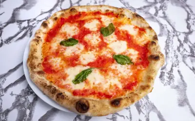 Idealne ciasto na pizzę neapolitańską z pomidorami, mozzarellą i bazylią.
