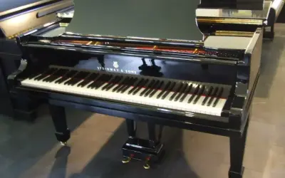 Błyszczący fortepian Steinway & Sons, jeden z najbardziej cenionych **marek fortepianów**, gotowy do wykonania pięknej melodii.