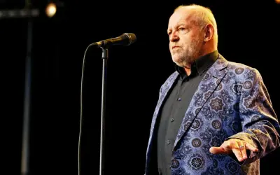 Joe Cocker w swojej charakterystycznej marynarce, gotów zaśpiewać swoje niezapomniane utwory.