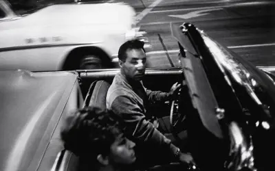 Garry Winogrand uchwycił nocną jazdę kabrioletem. Mężczyzna za kierownicą, kobieta obok. Rozmyte światła miasta.