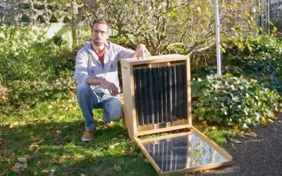 Un homme présente un séchoir solaire plan, un appareil ingénieux pour sécher des aliments grâce à l'énergie du soleil.