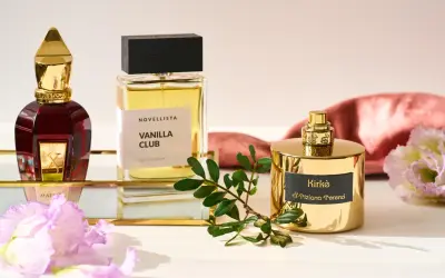 Eleganckie flakony edp perfumy: czerwony Xerjoff, Vanilla Club Novellista i złoty Kirke Tiziana Terenzi, otoczone kwiatami i gałązką.
