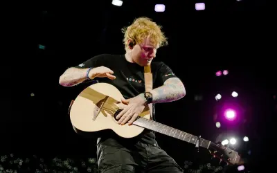 Ed Sheeran gra na gitarze, wykonując swój największy przebój na koncercie w Warszawie.
