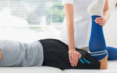 Un physiothérapeute aide un patient à étirer sa jambe pour soulager une crampe cuisse.