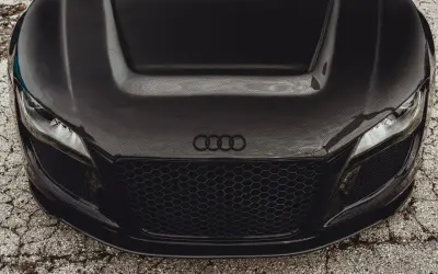 Maskownica i maska z włókna węglowego na czarnym aucie sportowym Audi.