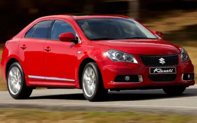 Czerwony sedan Suzuki Kizashi w ruchu.