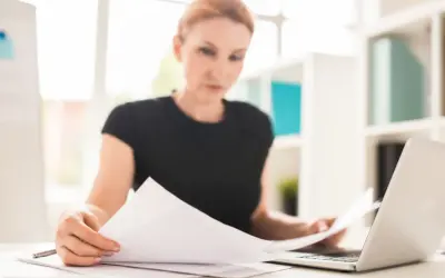 Kobieta analizuje dokumenty, być może dotyczące zakazu konkurencji po ustaniu stosunku pracy.