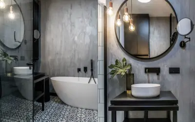 Nowoczesna łazienka w stylu loft z wolnostojącą wanną, umywalką nablatową i betonową ścianą.