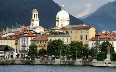 Vista sul lungolago di Stresa, con edifici colorati e cupole, ideale per scoprire cosa vedere in un giorno sul Lago Maggiore.