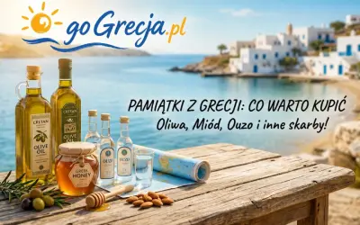 Oliwa, miód, ouzo – co przywieźć z Grecji? Pamiątki z wakacji na drewnianym stole z widokiem na grecką wyspę.
