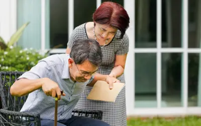 Una donna aiuta un uomo con bastone a rialzarsi. La speranza è che la paraplegia si può guarire, con supporto e cure.
