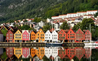 Kolorowe kamienice Bryggen w Bergen, wpisane na listę UNESCO, odbijają się w wodzie. Idealne miejsce, by zobaczyć, co oferuje to norweskie miasto.