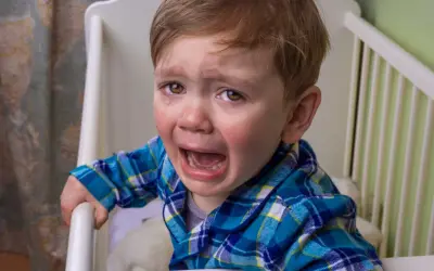 Niño de 10 años llorando en su cuna, se comporta como bebé.