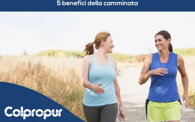 Due donne sorridono mentre camminano su un sentiero, godendosi i benefici della camminata.