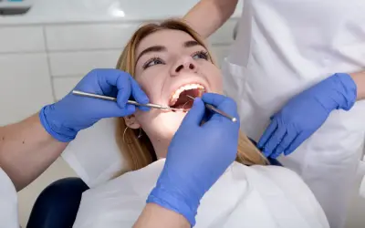 Dentysta bada zęby pacjentki. Czy plomba może wypaść? Specjalista ocenia stan uzębienia.