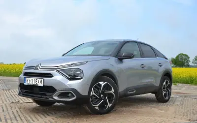 Srebrny Citroën C4 na tle kwitnącego pola rzepaku. Stylowy design i nowoczesne linie tego c4 zachwycają.