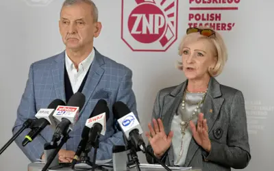 Dwoje przedstawicieli ZNP, związku zawodowego nauczycieli, podczas konferencji prasowej. Mężczyzna w kratę, kobieta w szarym żakiecie.