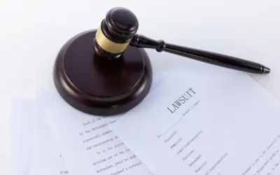 Młotek sędziowski na dokumentach sądowych, w tym na formularzu "LAWSUIT". Może posłużyć jako wzór wniosku o alimenty bez rozwodu.