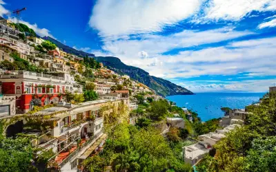 Positano, z czego słyną Włochy: kolorowe domy na zboczu góry, błękitne morze i łodzie.