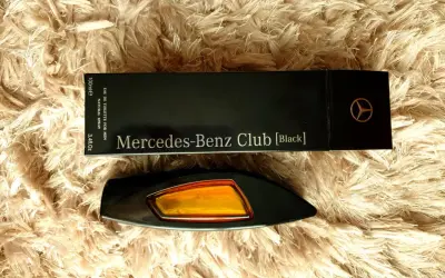 Elegancki flakon perfum Mercedes-Benz Club [Black] na puszystym tle.