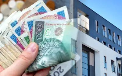 Dłoń trzyma polskie banknoty, symbolizujące kredyt na wkład własny na zakup nowoczesnego mieszkania.